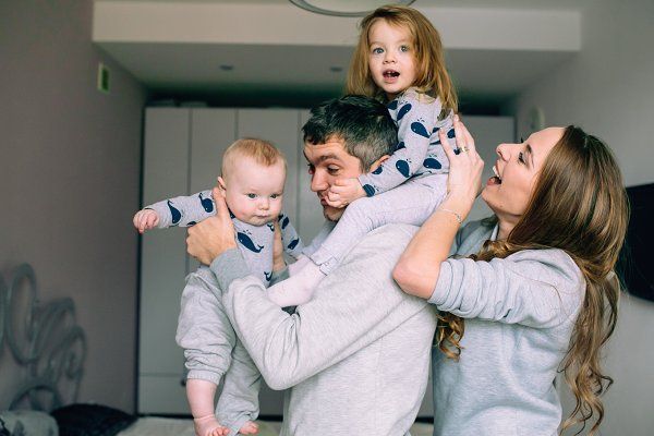 Papá y mamá jugando junto a sus bebés mientras están en la cocina 