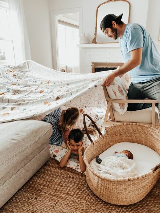 Papá construyendo un fuerte para que sus hijos jueguen 