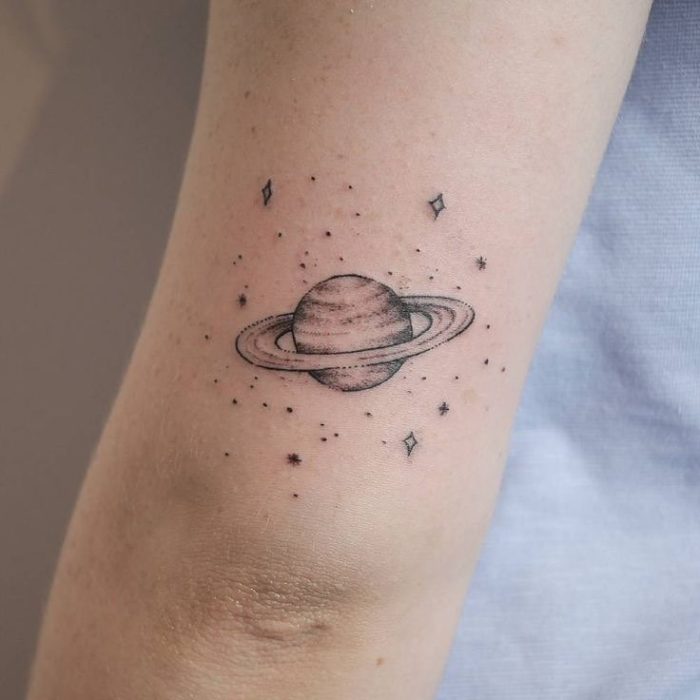 Tatuaje encima del codo del planeta Saturno