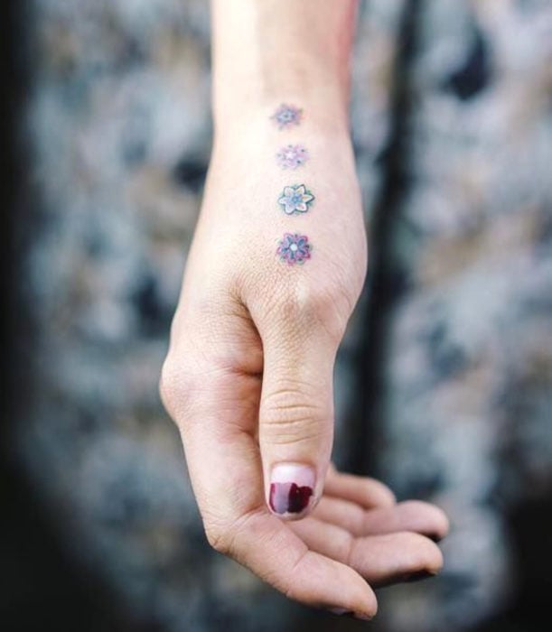 Tatuajes femeninos y discretos en las manos; flores