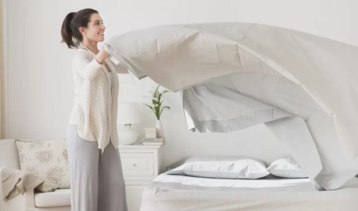 Mujer tendiendo su cama