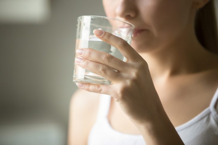 Chica usando como enjuague bucal agua oxigenada con agua natural