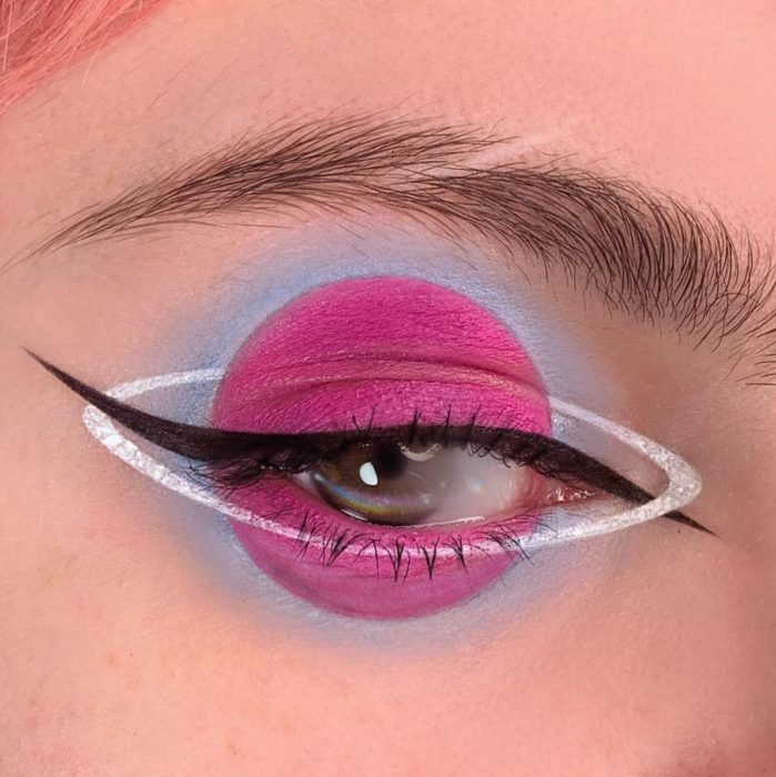 Sombra para ojos en tono rosa fucsia en forma de planeta con delineado blanco y negro 