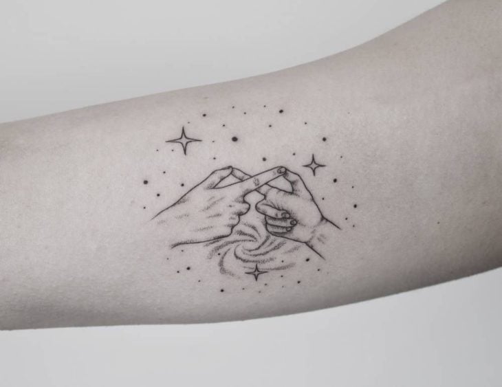 Tatuaje de madre e hija haciéndo con los los dedos el símbolo de infinito