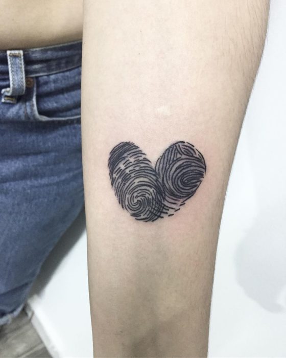 Tatuaje de madre e hija, de un corazón formado con las huelas dactilares