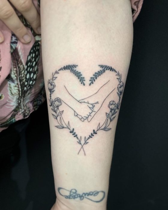 tatuaje madre e hija, agarrandose las manos y un corazón al rededor de ella