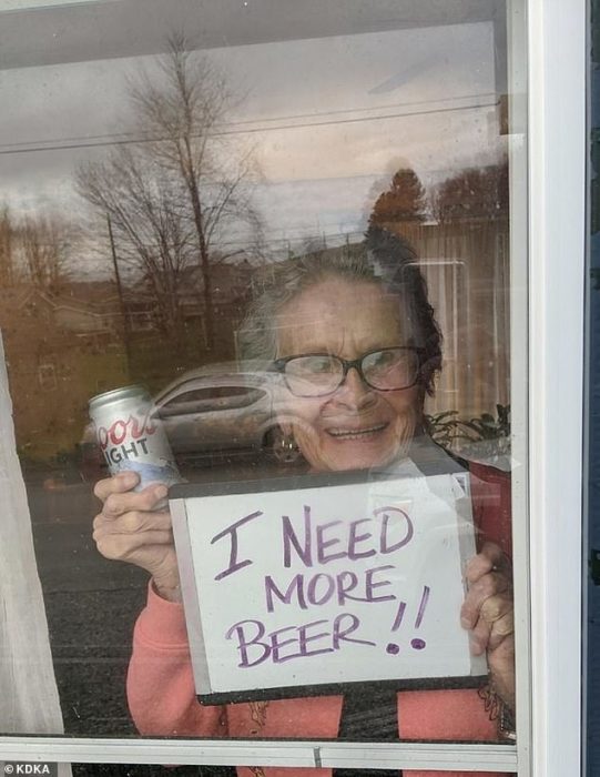 Abuelita en cuarentena sostiene letrero pidiendo más cerveza 