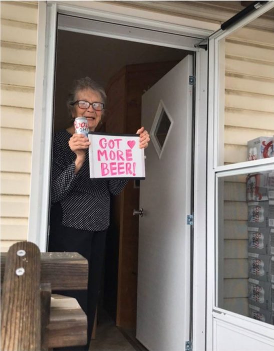 Abuelita en cuarentena sostiene letrero que asegura ya tiene cerveza suficiente