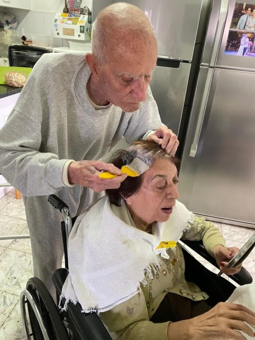 Hombre mayor ayuda a su esposa a pintarse el pelo