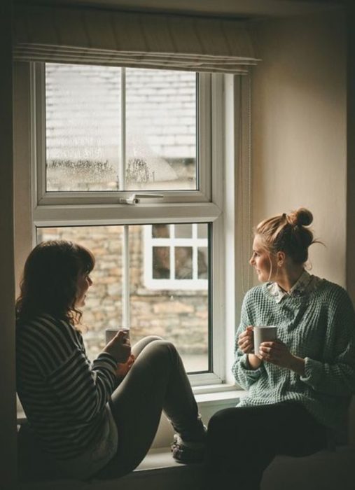 Par de amigas tomando café mientras platican