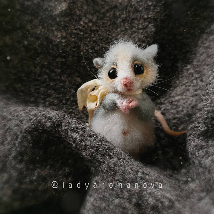 Figura de fieltro creada por la artista rusa Anna Romanova, ratoncito gris comiendo queso 