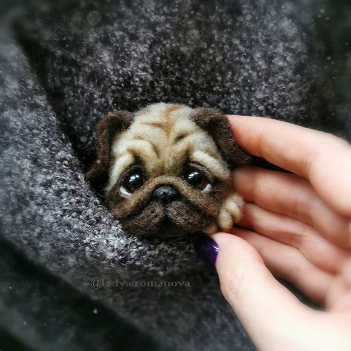 Figura de fieltro creada por la artista rusa Anna Romanova perro pug dentro de un saco gris oscuro