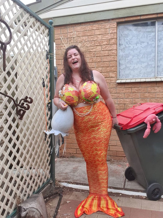 Mujer vestida como sirena lista para sacar la basura 