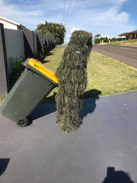 Persona usando un disfraz de camuflaje para sacar la basura 