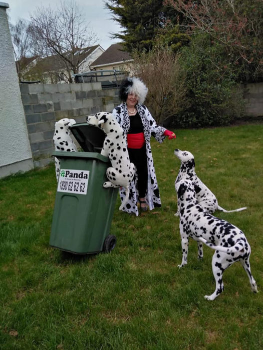 Mujer vestida de Cruella DeVil sacando la basura fuera de su casa 