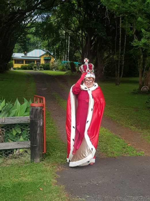 Señora vestida de reina con un traje rojo con capa 