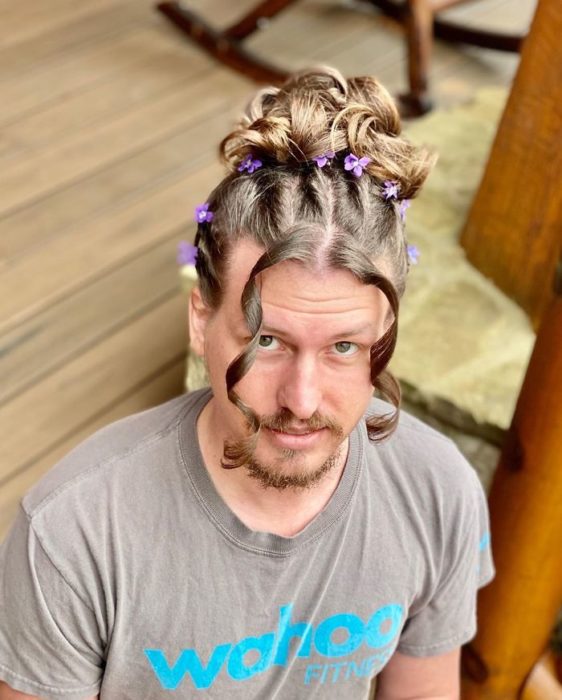 Chico con el cabello peinado con un chongo y risos 