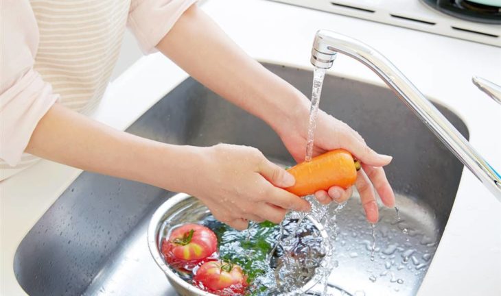 Mujer lavando frutas y verduras