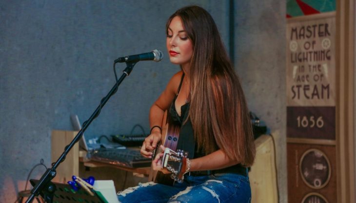 Chica tocando la guitarra y cantando