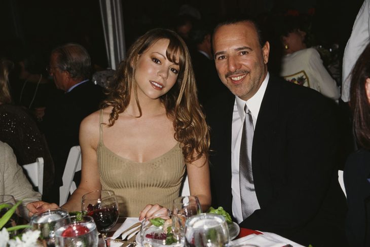 Tommy Motola sentado junto a Mariah Carey durante una cena 