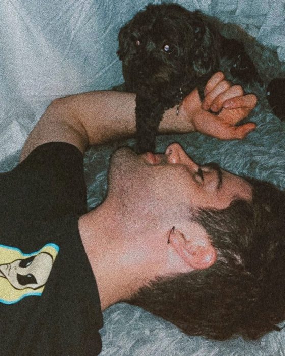 Max Ehrich recostado junto a su perro 