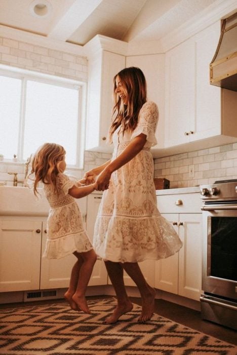 Madre e hija bailando mientras están en la cocina 
