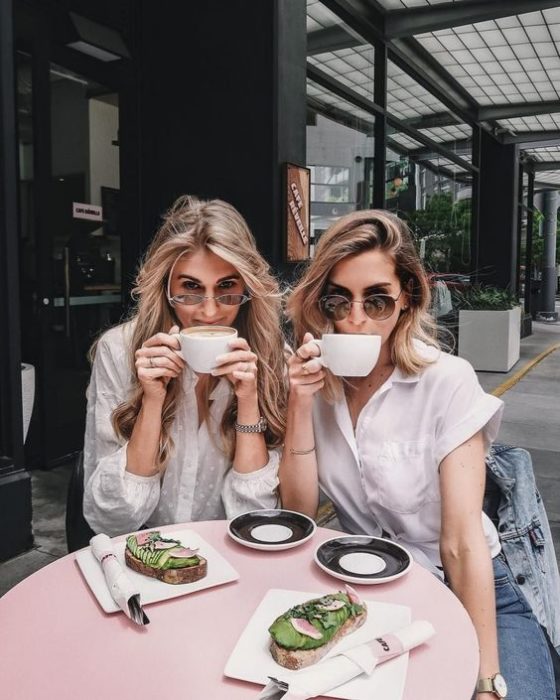 Madre e hija rubias tomando café con gafas de sol