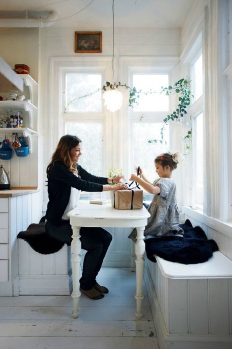 Madre e hija abriendo regalos en la mesa de la cocina