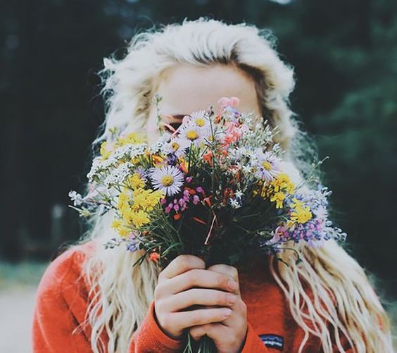 Chica rubia sosteniendo ramo de flores