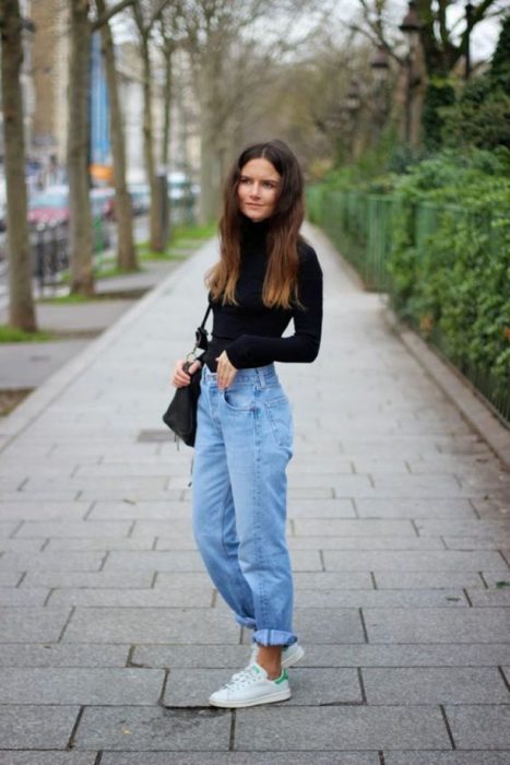 Chica usando mom jeans y blusa negra de manga larga