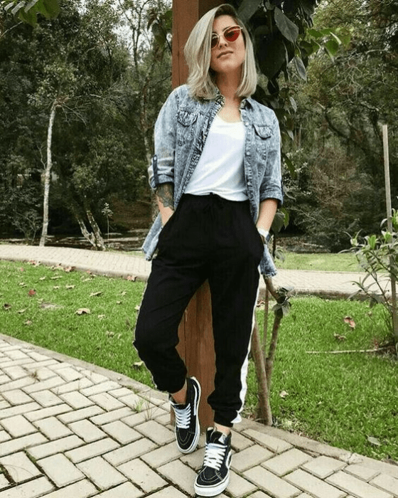 Chica usando pantalones negros, blusa blanca y una camisa demin