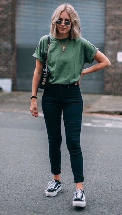 Chica usando skinny jeans de color negro y blusa de color verde 