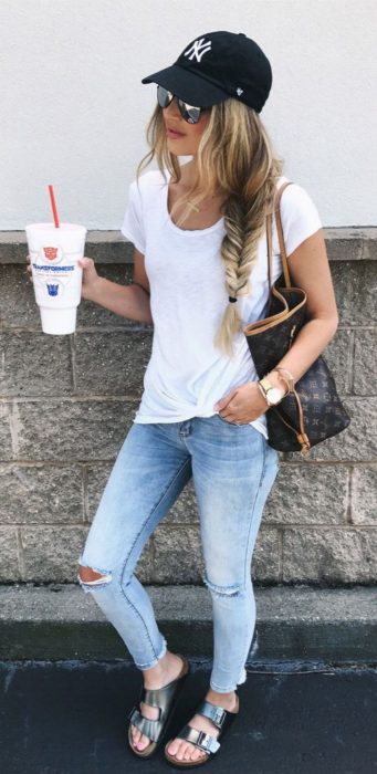 Chica usando skinny jeans con blusa blanca y gorra de beisbolista 