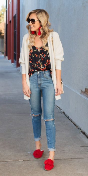 Chica usando skinny jeans con zapatos de color rojo, blusa negra y cardigan blanco 