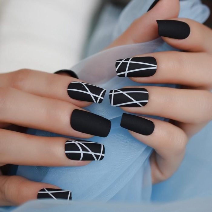 Manicura en color negro con lineas blancas