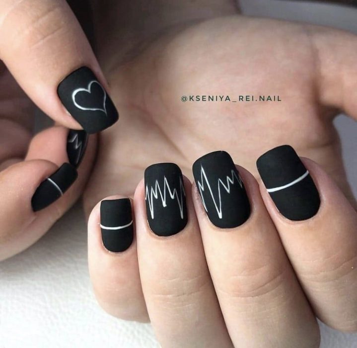 Manicura en color negro con diseño de lineas en blanco y efecto mate