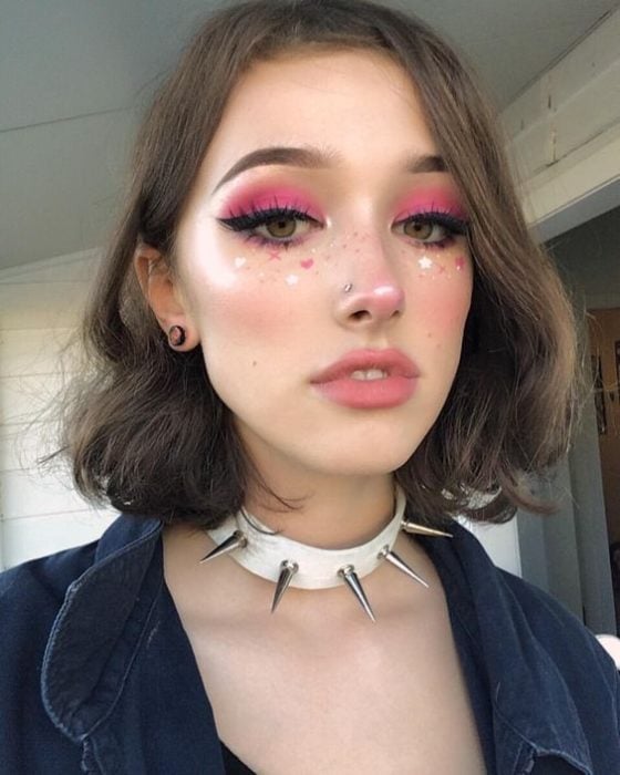 Chica de cabello corto y castaño con sombras rosas 
