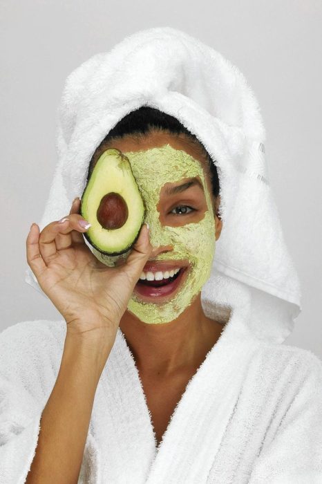 Chica con mascarilla de aguacate en el rostro