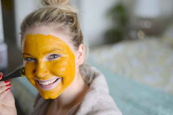 Chica usando mascarilla de cúrcuma sobre la piel