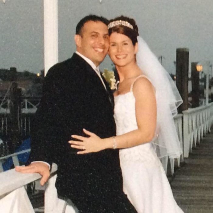 Mujer abrazando a su esposo el día de su boda durante una sesión de fotos en un puente 