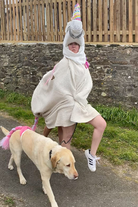 Mujer usa disfraz de unicornio mientras pasea a su perro