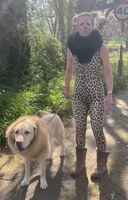 Mujer usa disfraz de cheeta mientras pasea a su perro