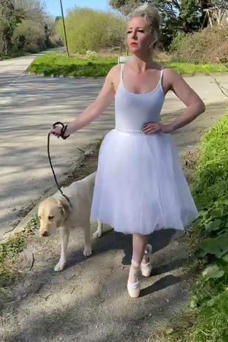 Mujer vestida de bailarina pasea con perro