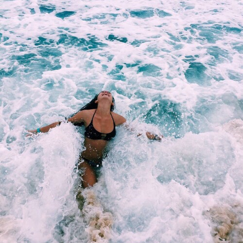 Chica nada feliz en las olas del mar