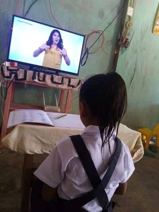 Niña se pone su uniforme y se peina para sus clases online