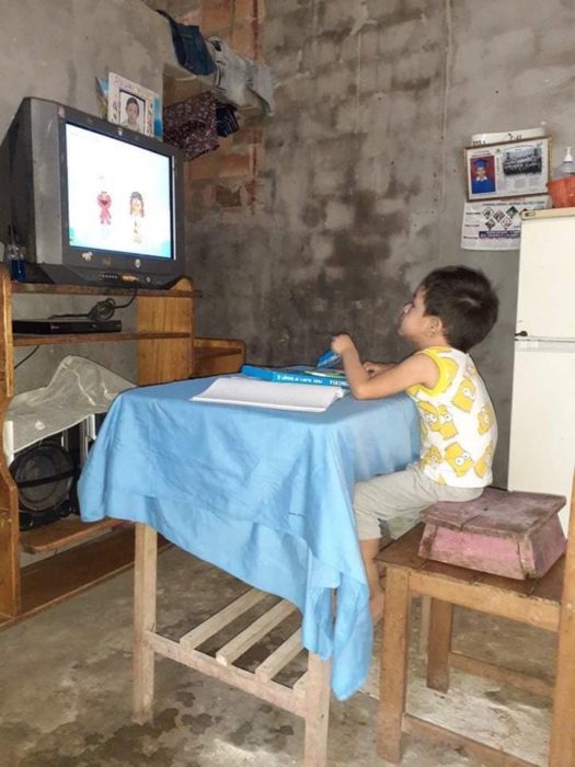 Niño pequeño sentado en una silla haciendo tarea