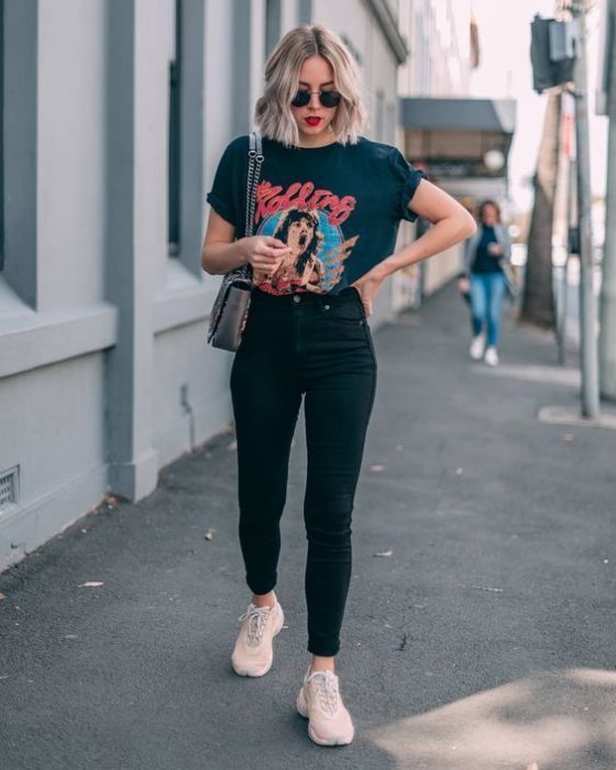 Chica con blusa y pantalón negros y tenis rosas