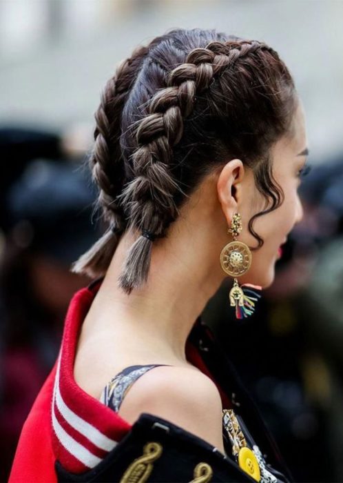 Chica con el cabello corto sujetado en dos trenzas 