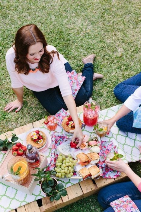 Madre e hija disfrutando de un día de picnic en el jardín de la casa 