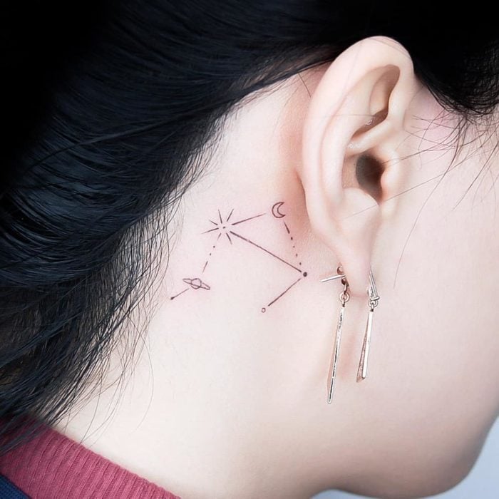 Tatuaje detrás de la oreja de una constelación